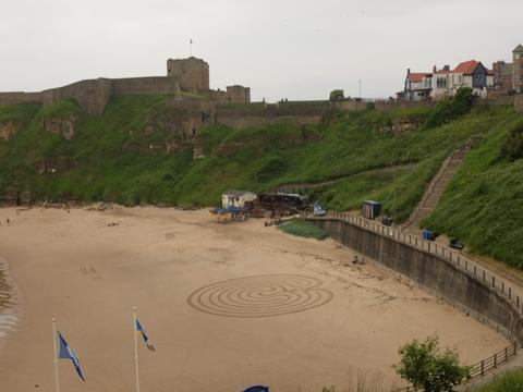 Sandy bay beneath a clifftop priory