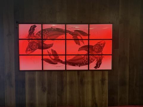 Red backlit artwork on a timber wall