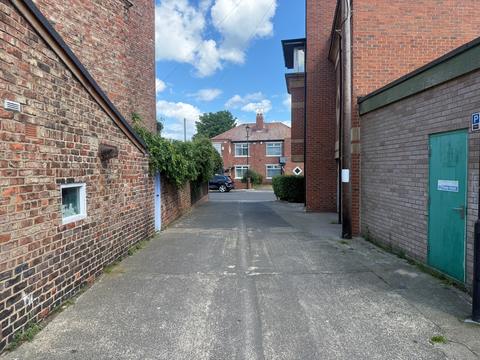 Back lane between red-brick buildings
