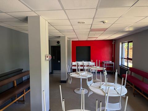 Café with white tables and a red wall